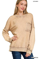 Blonde woman wearing a boyfriend fit drop shoulder sweatshirt pullover, with front pocket accent, exposed raw seams, and all over acid wash detail.