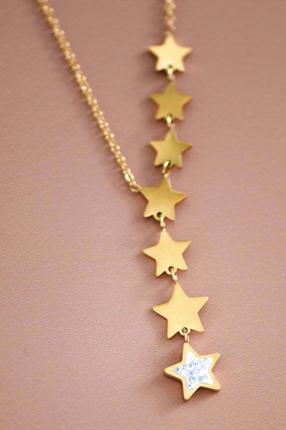 Gold star necklace on a brown background