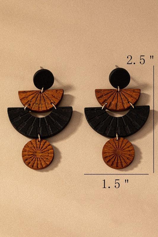 Pair of earrings with wooden and black geometric design, shown on a beige background with measurements.