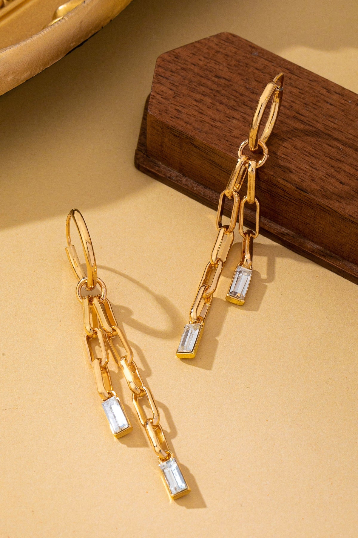 Paperclip Chain Dangle Design: Features double-strand paperclip link chains dangling in asymmetrical lengths for fluid movement.