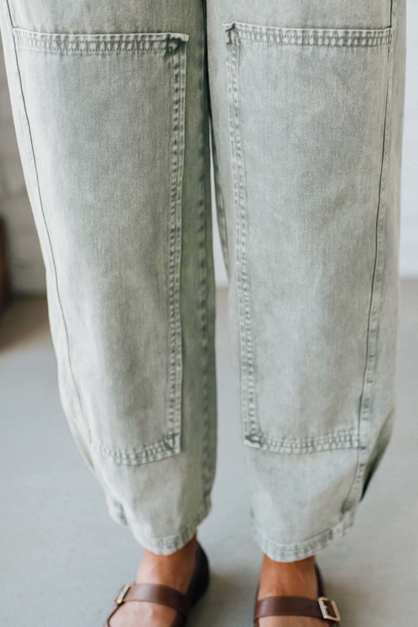 Blonde woman wearing Mineral Washed Mid Rise Barrel Shape Pants with patch detail on leg.