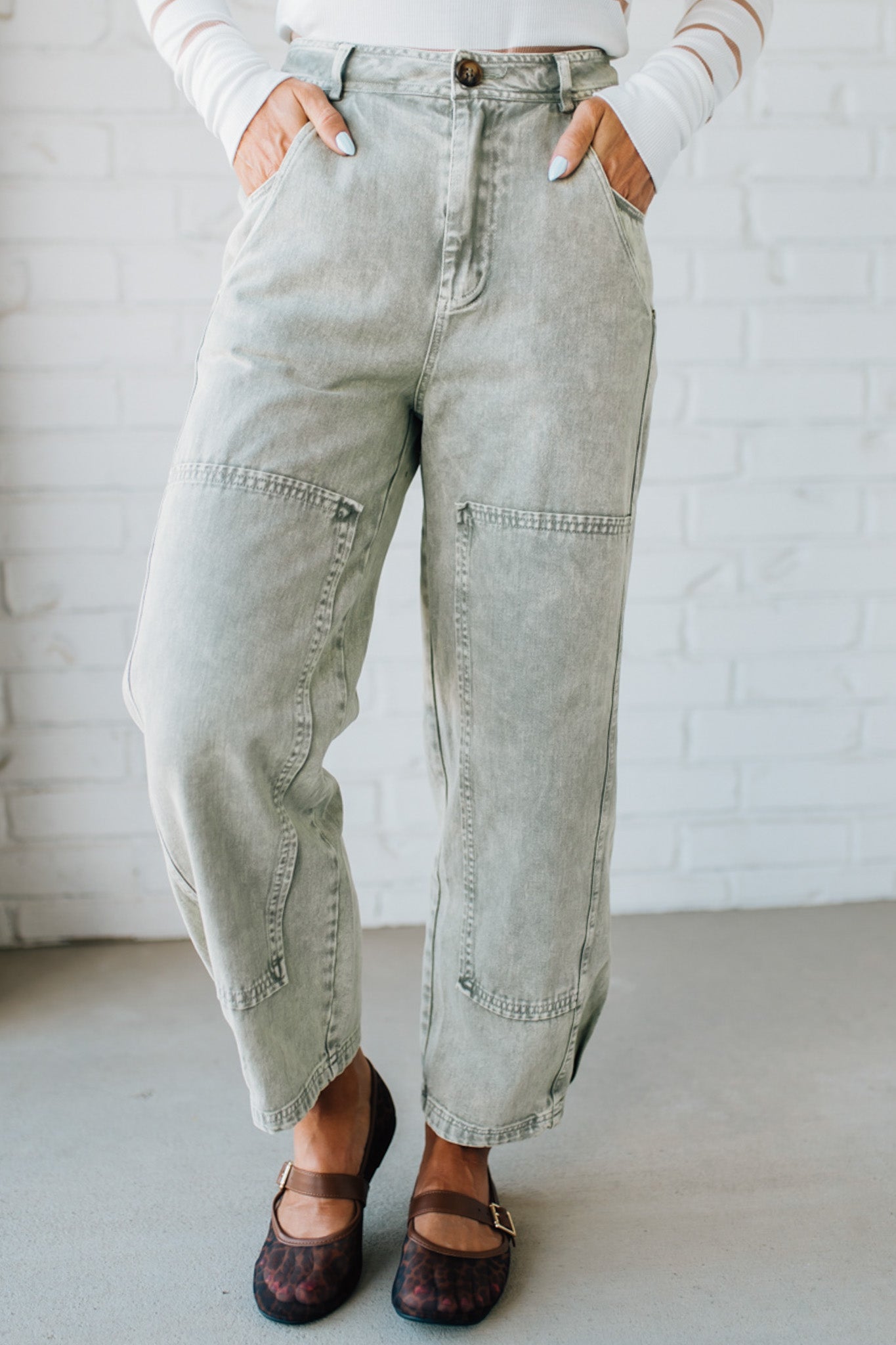 Blonde woman wearing Mineral Washed Mid Rise Barrel Shape Pants with patch detail on leg.