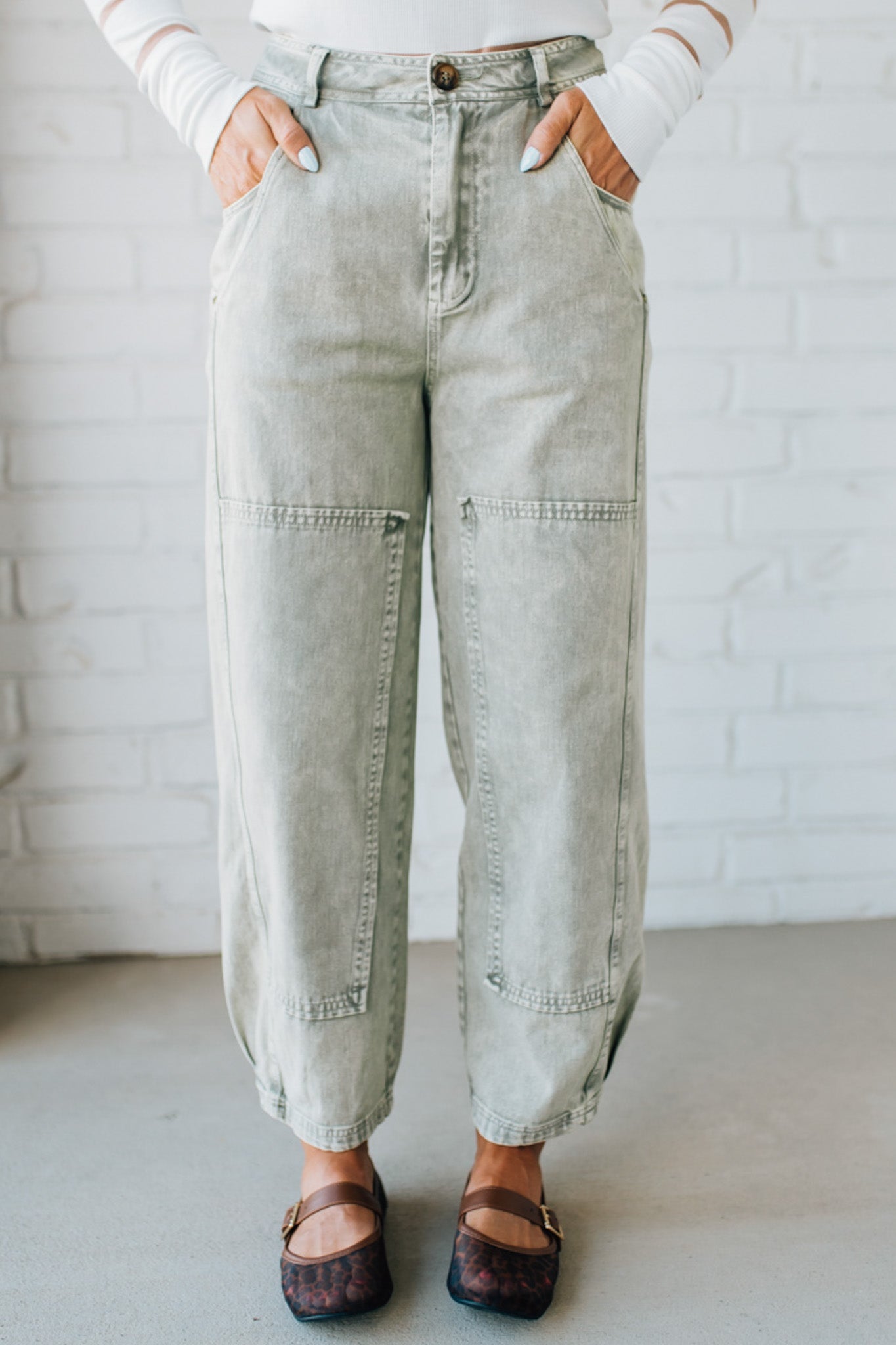 Blonde woman wearing Mineral Washed Mid Rise Barrel Shape Pants with patch detail on leg.