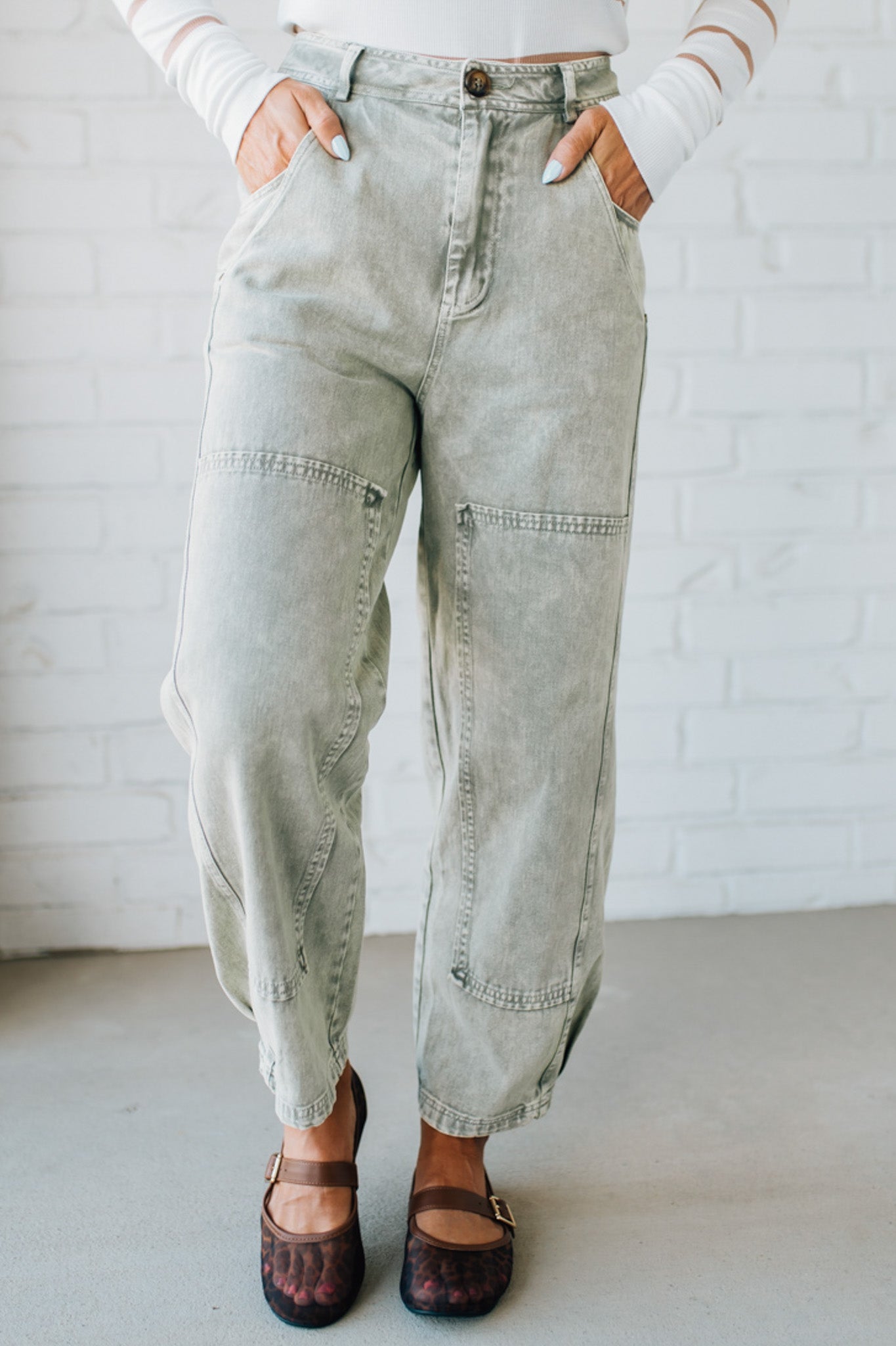 Blonde woman wearing Mineral Washed Mid Rise Barrel Shape Pants with patch detail on leg.