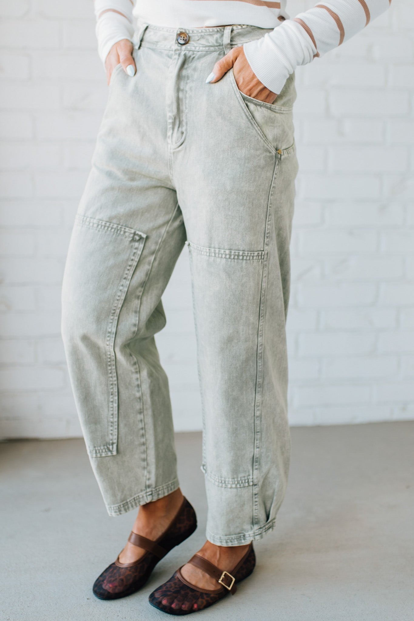 Blonde woman wearing Mineral Washed Mid Rise Barrel Shape Pants with patch detail on leg.