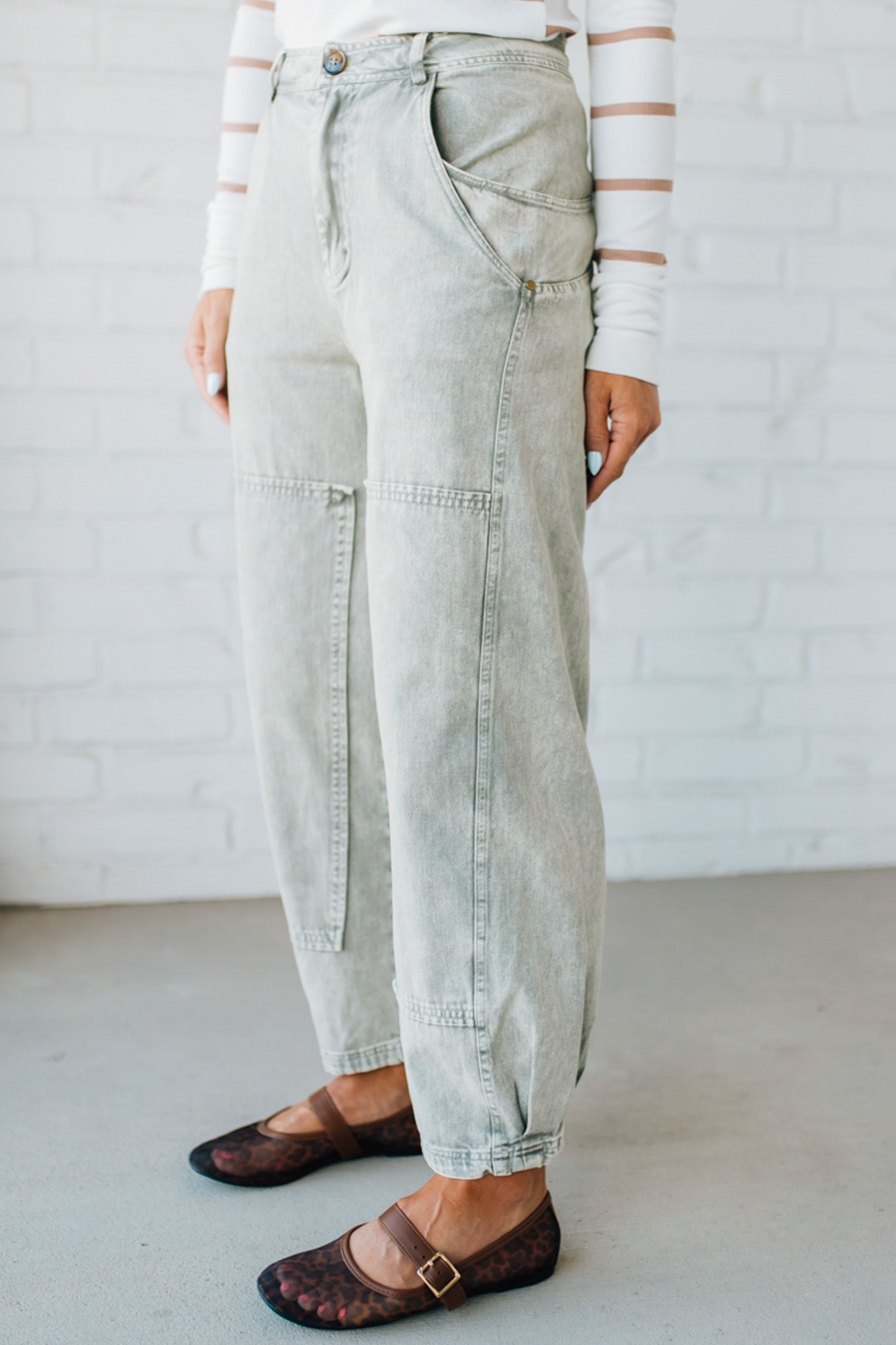 Blonde woman wearing Mineral Washed Mid Rise Barrel Shape Pants with patch detail on leg.