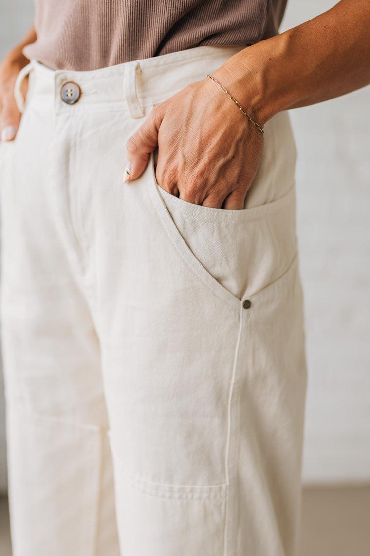 Close-up of a person wearing beige pants with a neutral background