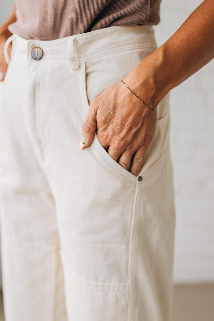Person wearing white pants with a neutral background
