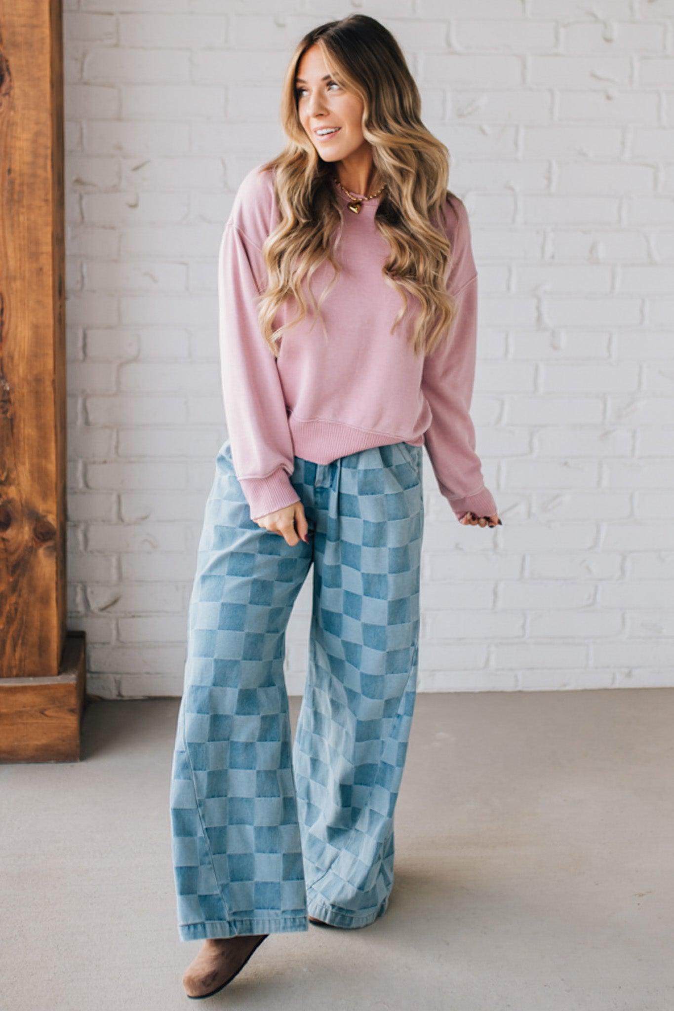 BLONDE WOMAN MODELING A LONG SLEEVE ACID WASHED PULLOVER WITH RIBBED DETAIL ON THE NECKLINE, SLEEVE CUFFS AND HEMLINE