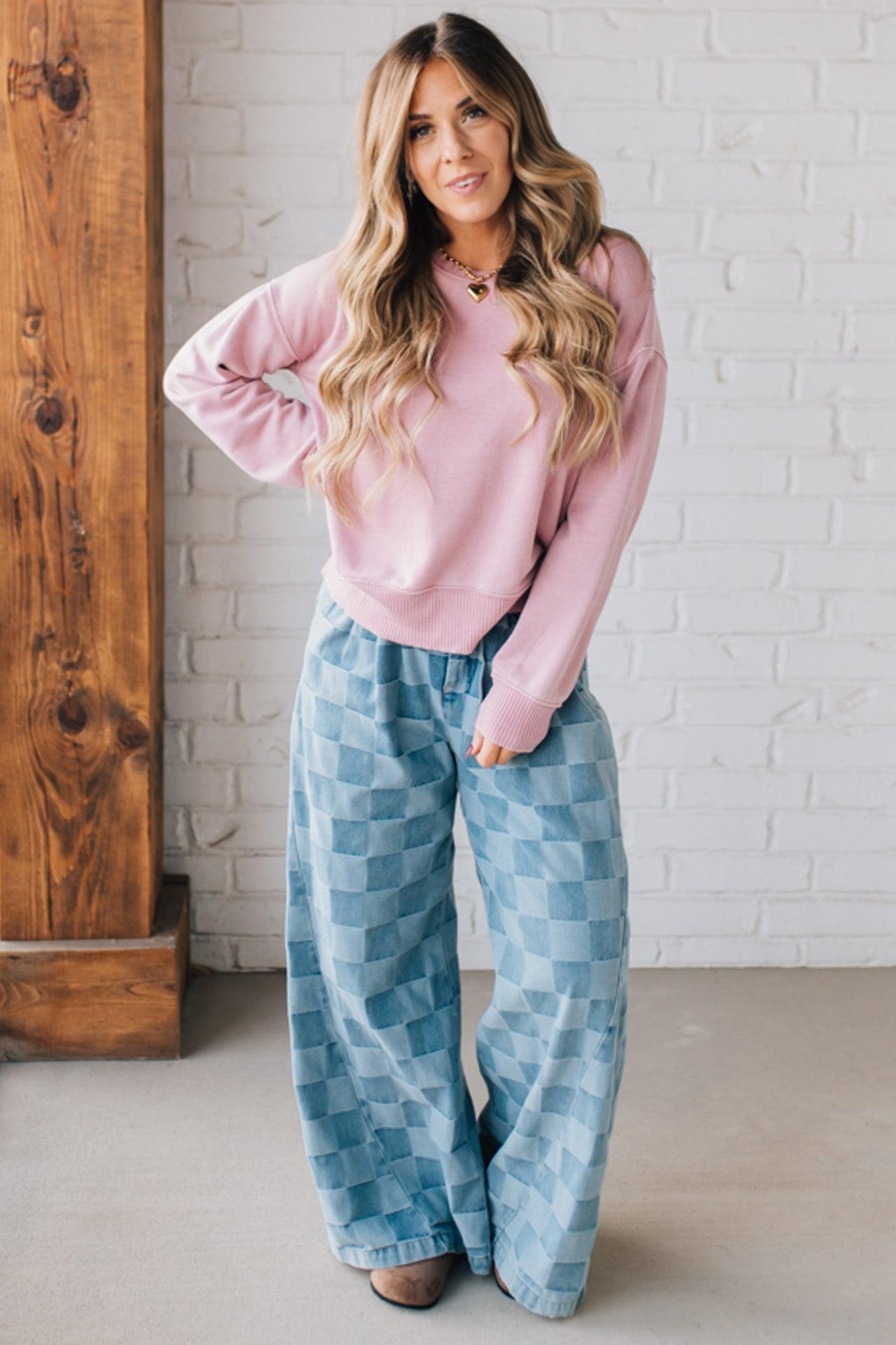 BLONDE WOMAN MODELING A LONG SLEEVE ACID WASHED PULLOVER WITH RIBBED DETAIL ON THE NECKLINE, SLEEVE CUFFS AND HEMLINE