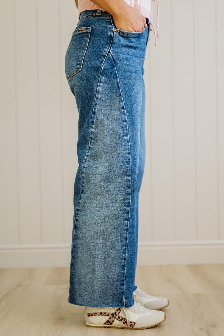 Person wearing blue jeans with a neutral background