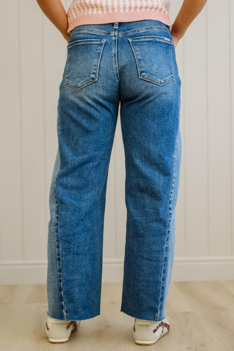 Person wearing blue jeans standing against a plain background