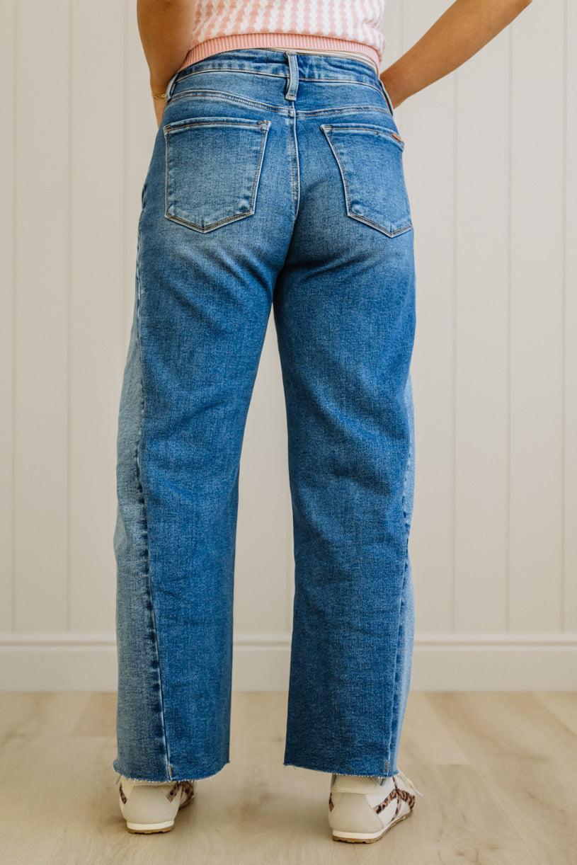 Person wearing blue jeans with a neutral background