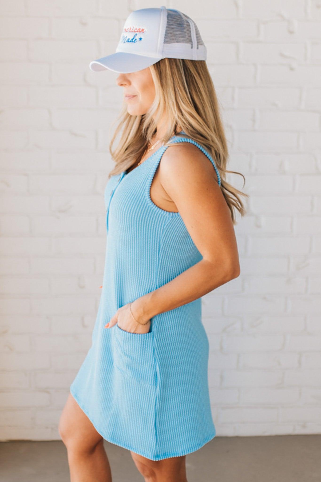 BLONDE WOMAN MODELING A RIBBED TANK DRESS WITH HENLEY STYLE WOOD BUTTONS AND TWO FRONT POCKETS