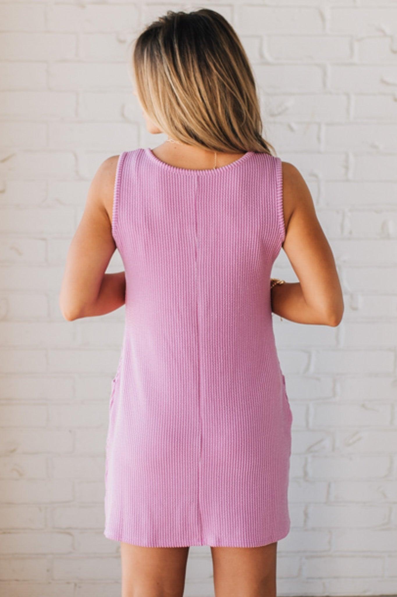 BLONDE WOMAN MODELING A RIBBED TANK DRESS WITH HENLEY STYLE WOOD BUTTONS AND TWO FRONT POCKETS