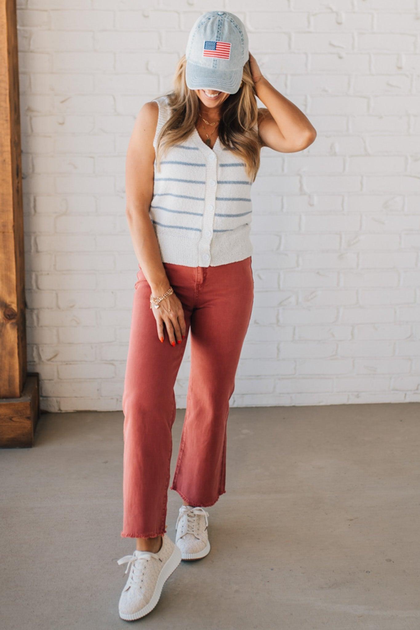 BLONDE WOMAN IN A HAT WEARING A LIGHTWEIGHT, COZY, STRIPED BUTTON UP V-NECK VEST W/ RIBBING ACCENTS THROUGHOUT BODY.