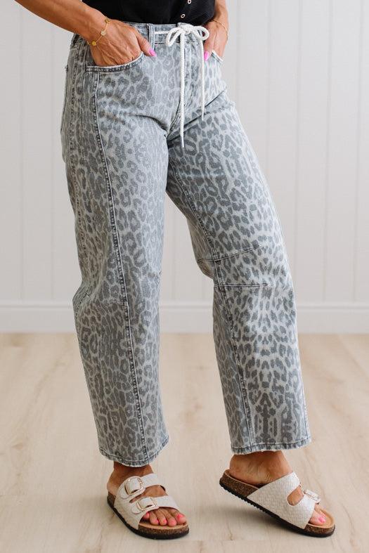 Person wearing leopard print pants with a white background