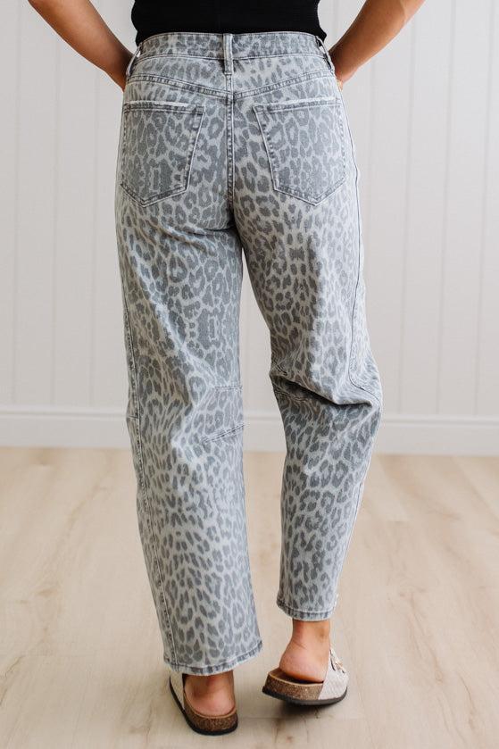 Person wearing gray leopard print pants on a plain background