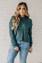 Blonde girl modeling a jade long sleeve cable knit sweater