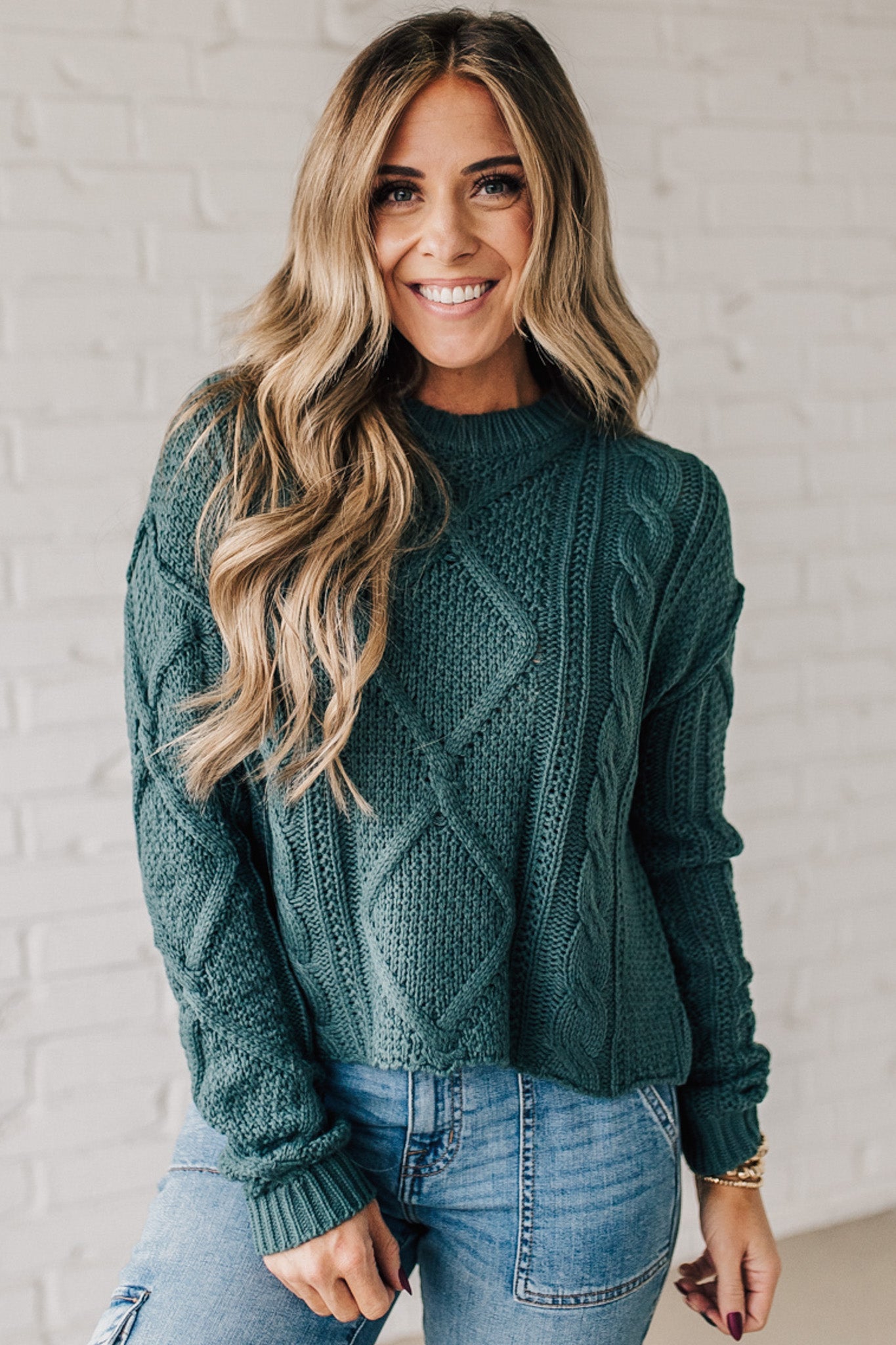 Blonde girl modeling a mocha long sleeve cable knit sweater