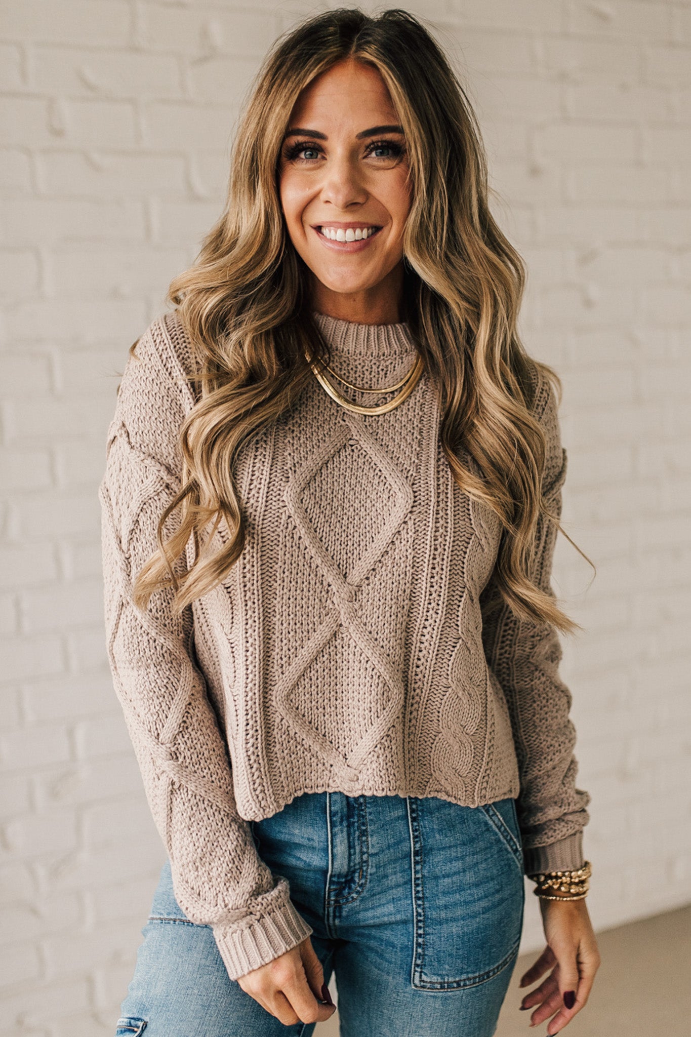 Blonde girl modeling a mocha long sleeve cable knit sweater