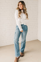 Blonde girl modeling a white long sleeve cable knit sweater