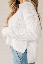 Blonde girl modeling a white long sleeve cable knit sweater