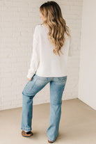 Blonde girl modeling a white long sleeve cable knit sweater