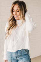 Blonde girl modeling a white long sleeve cable knit sweater