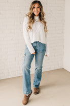 Blonde girl modeling a white long sleeve cable knit sweater