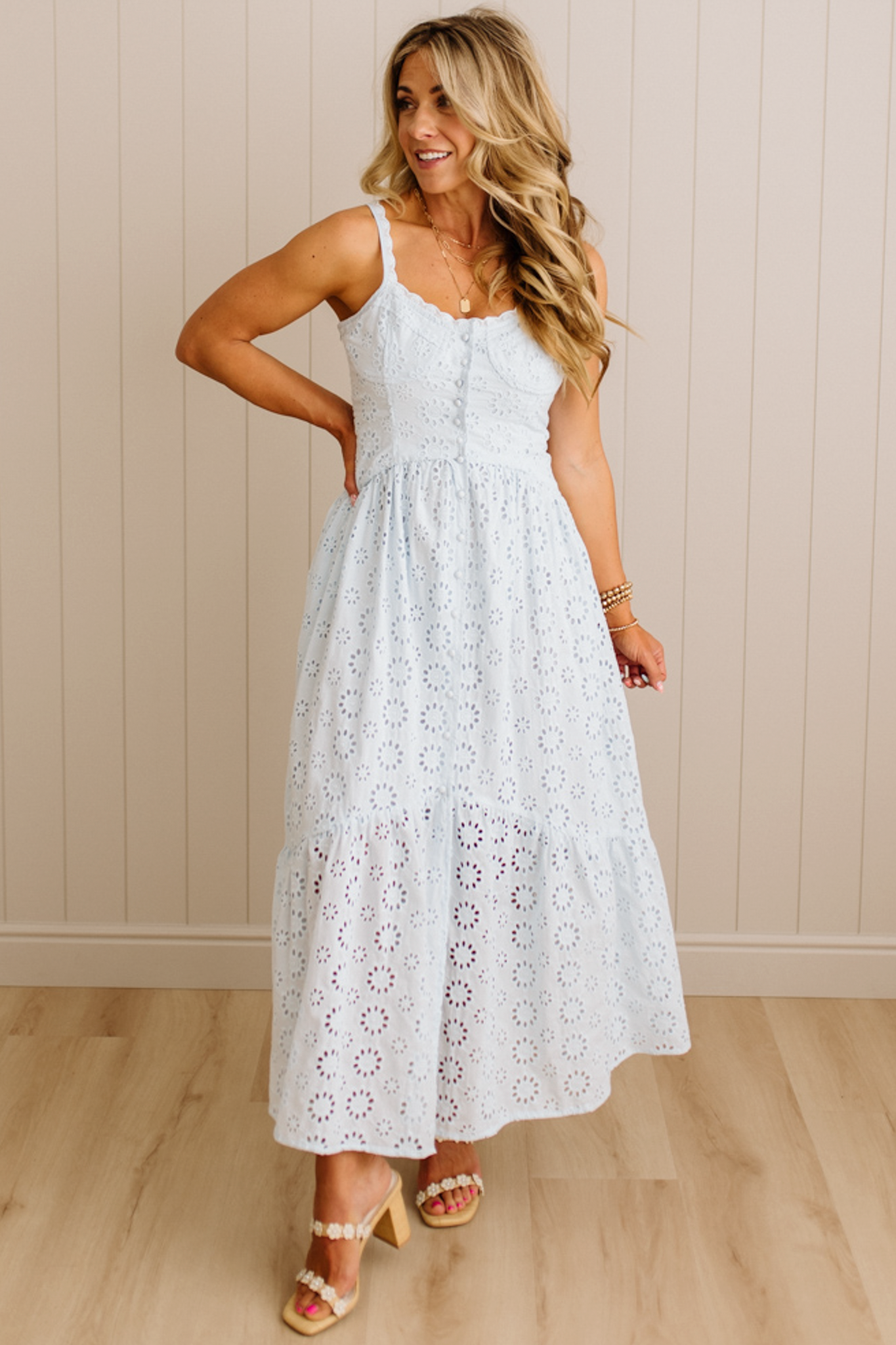 Blonde Woman wearing an eyelet lace dress with button front and spaghetti strap.