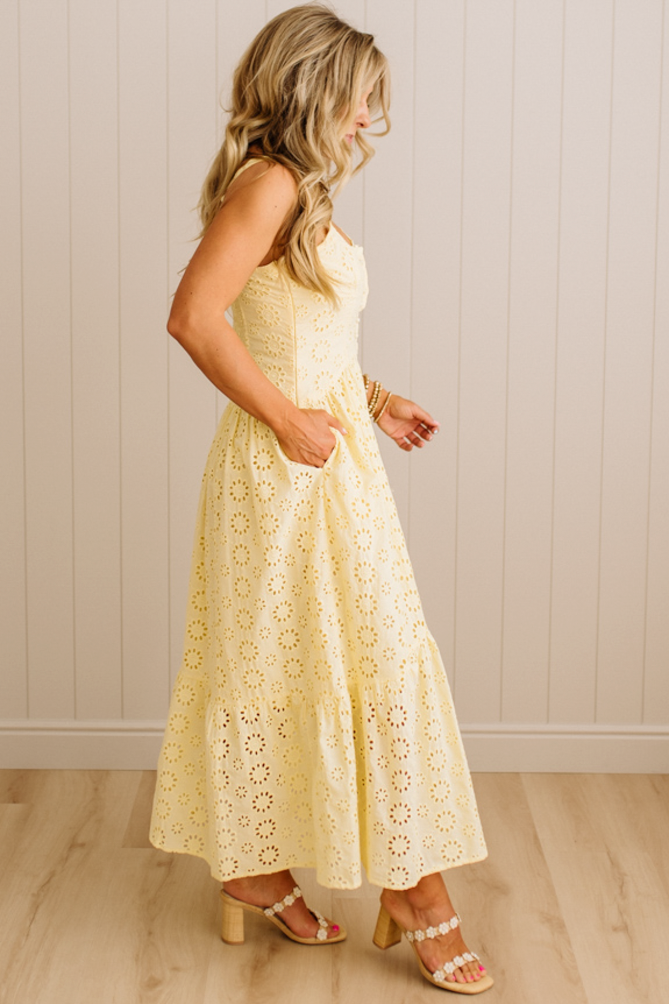 Blonde Woman wearing an eyelet lace dress with button front and spaghetti strap.