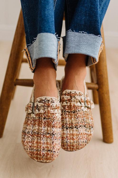 Womens footwear featuring a woven tweed upper with a statement buckle detail, set in an easy mule silhouette.