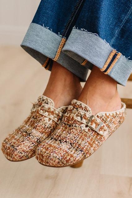 Womens footwear featuring a woven tweed upper with a statement buckle detail, set in an easy mule silhouette.
