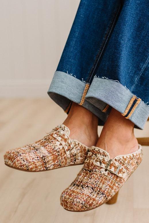 Womens footwear featuring a woven tweed upper with a statement buckle detail, set in an easy mule silhouette.