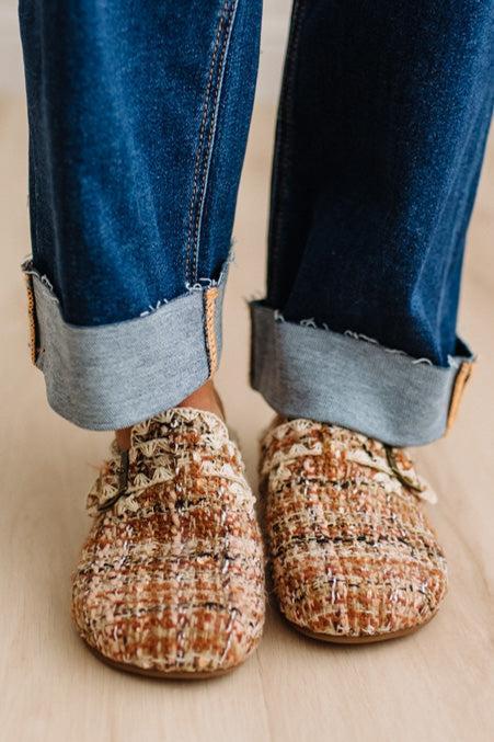 Womens footwear featuring a woven tweed upper with a statement buckle detail, set in an easy mule silhouette.