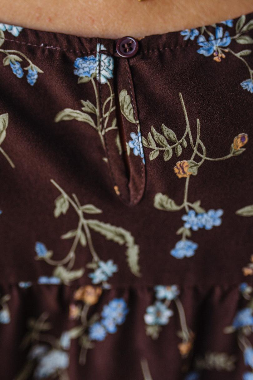 Close-up of a brown fabric with floral pattern and button