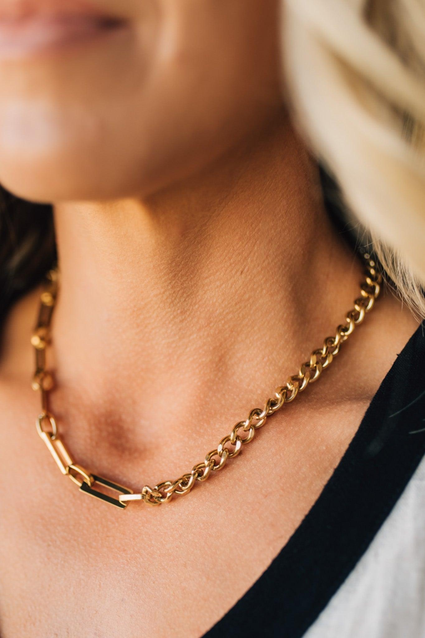 Gold chain necklace worn by a person