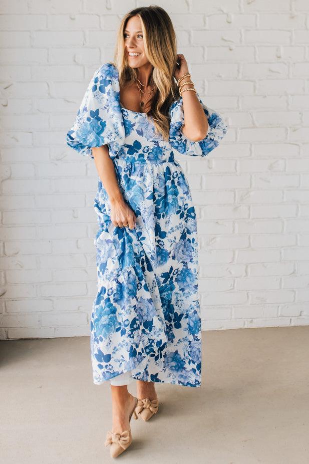 Blonde Woman Wearing a Floral Print Puff Sleeve Maxi Dress in Blue and White.