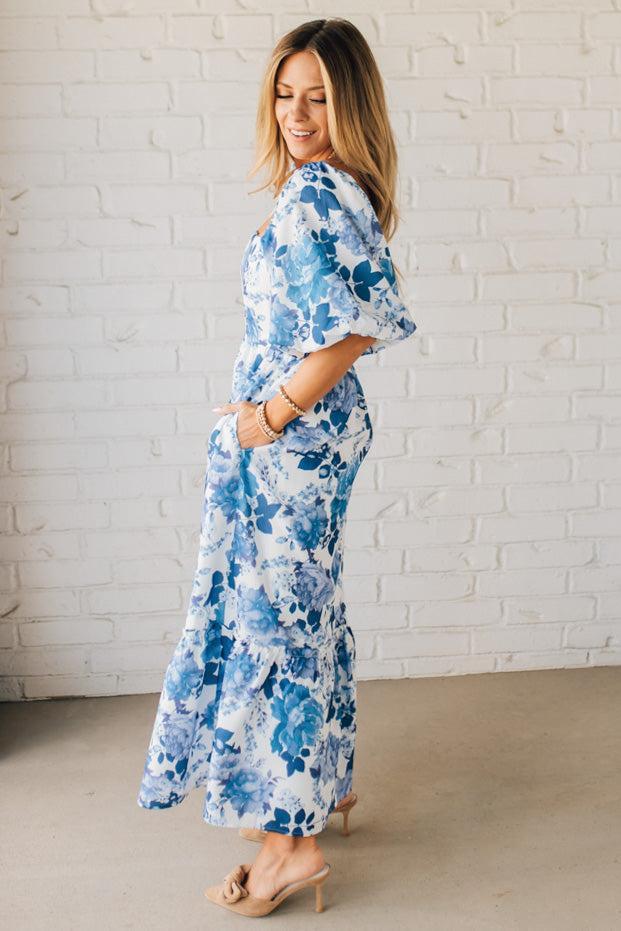 Blonde Woman Wearing a Floral Print Puff Sleeve Maxi Dress in Blue and White.