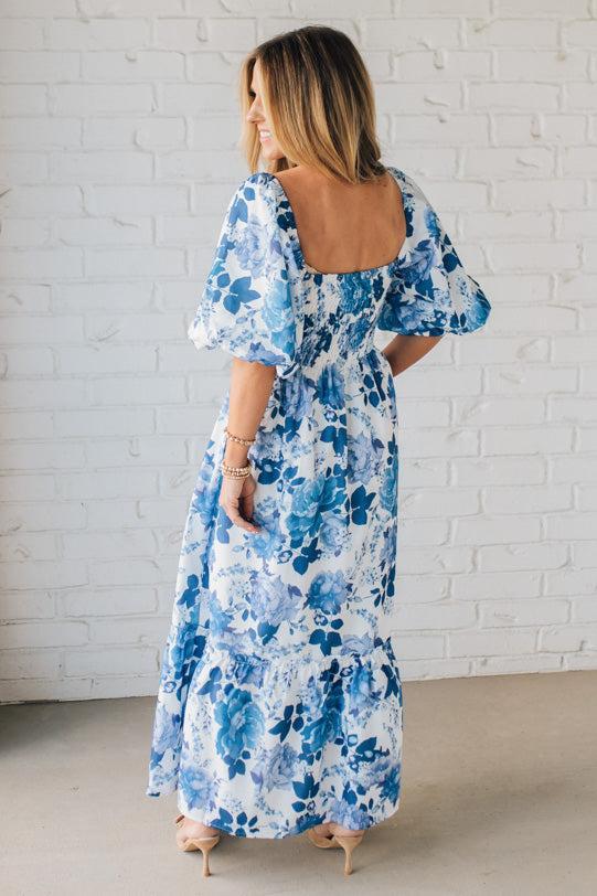 Blonde Woman Wearing a Floral Print Puff Sleeve Maxi Dress in Blue and White.