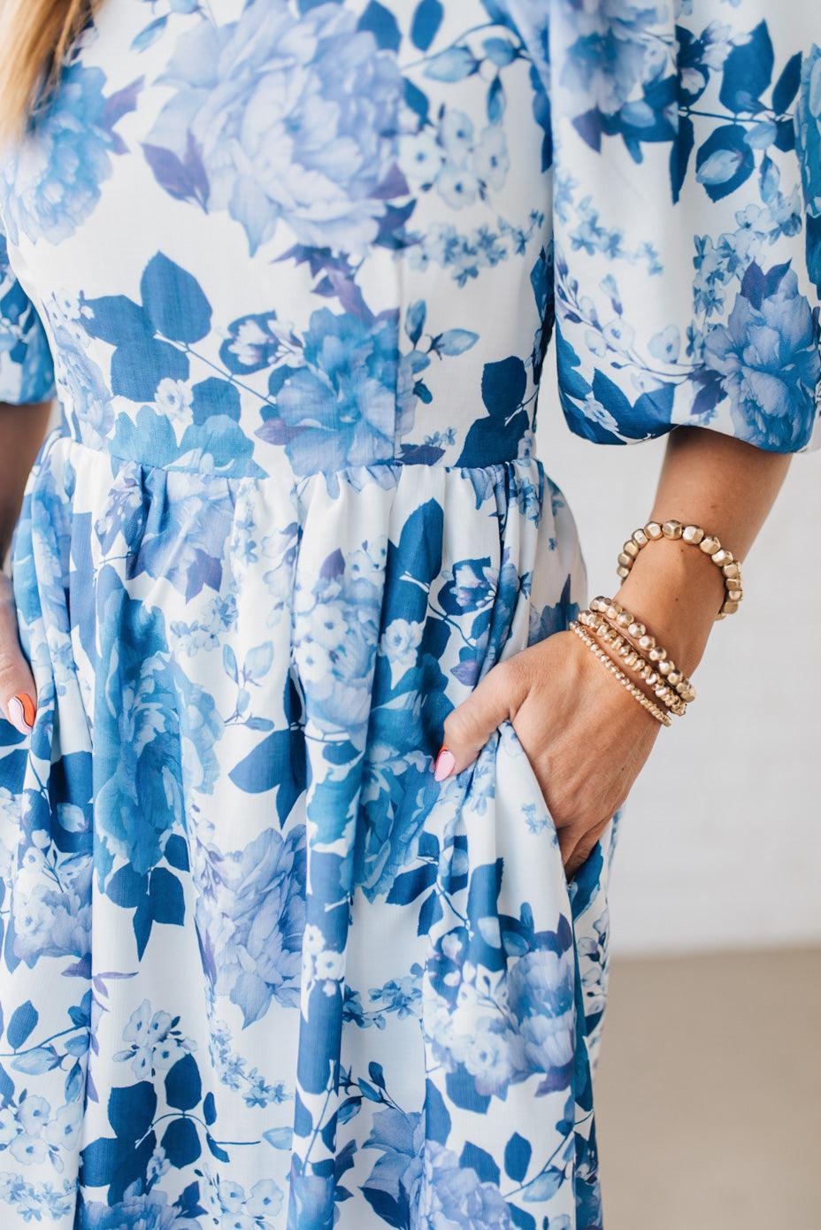 Blonde Woman Wearing a Floral Print Puff Sleeve Maxi Dress in Blue and White.