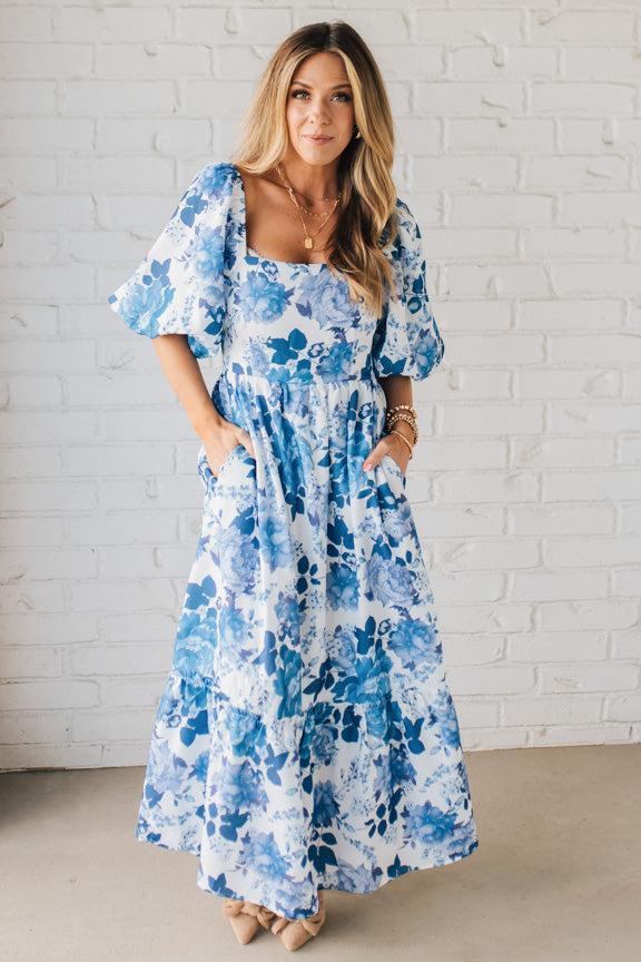 Blonde Woman Wearing a Floral Print Puff Sleeve Maxi Dress in Blue and White.