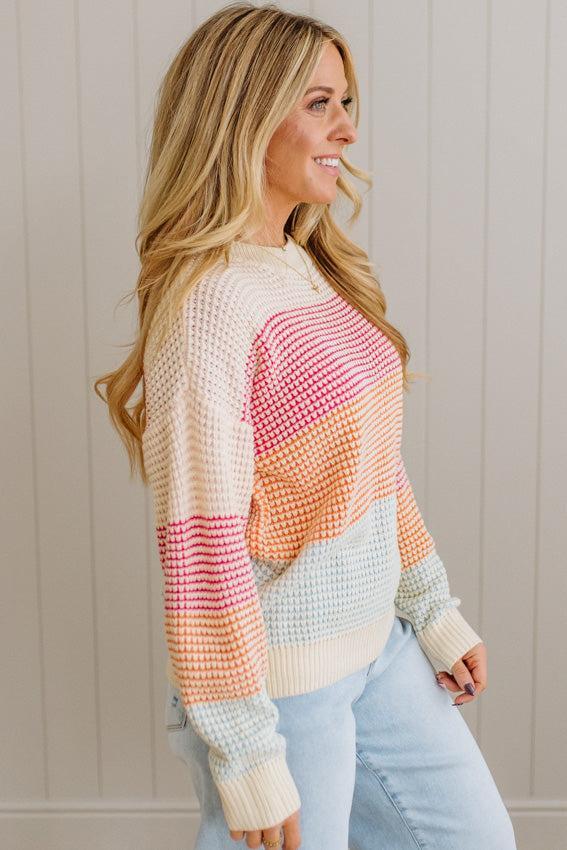 Woman wearing a colorful sweater with a neutral background