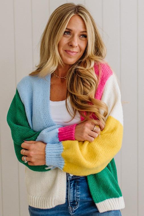 Woman wearing a colorful sweater with a neutral background