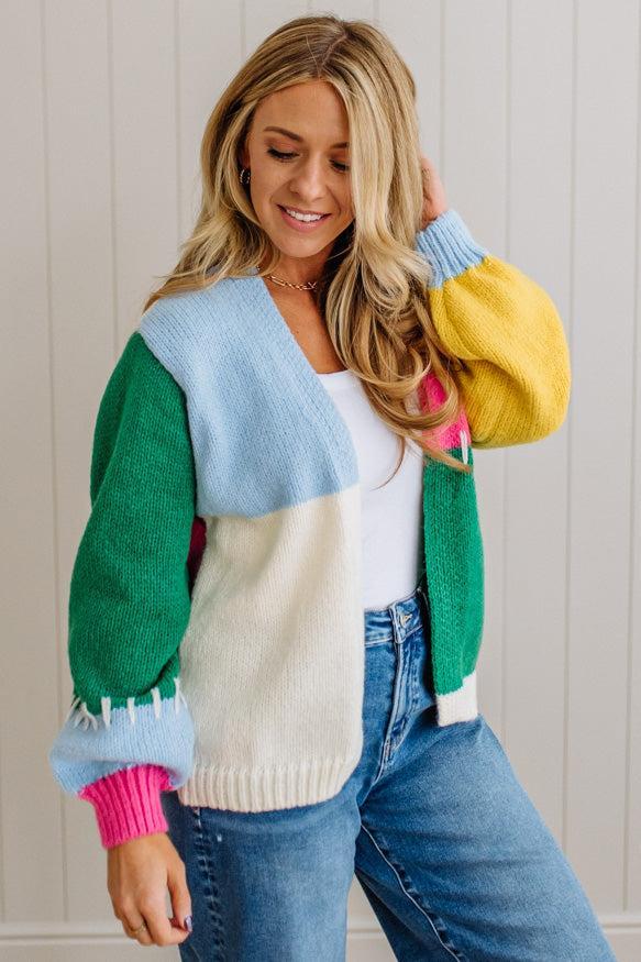 Woman wearing a colorful sweater with a neutral background