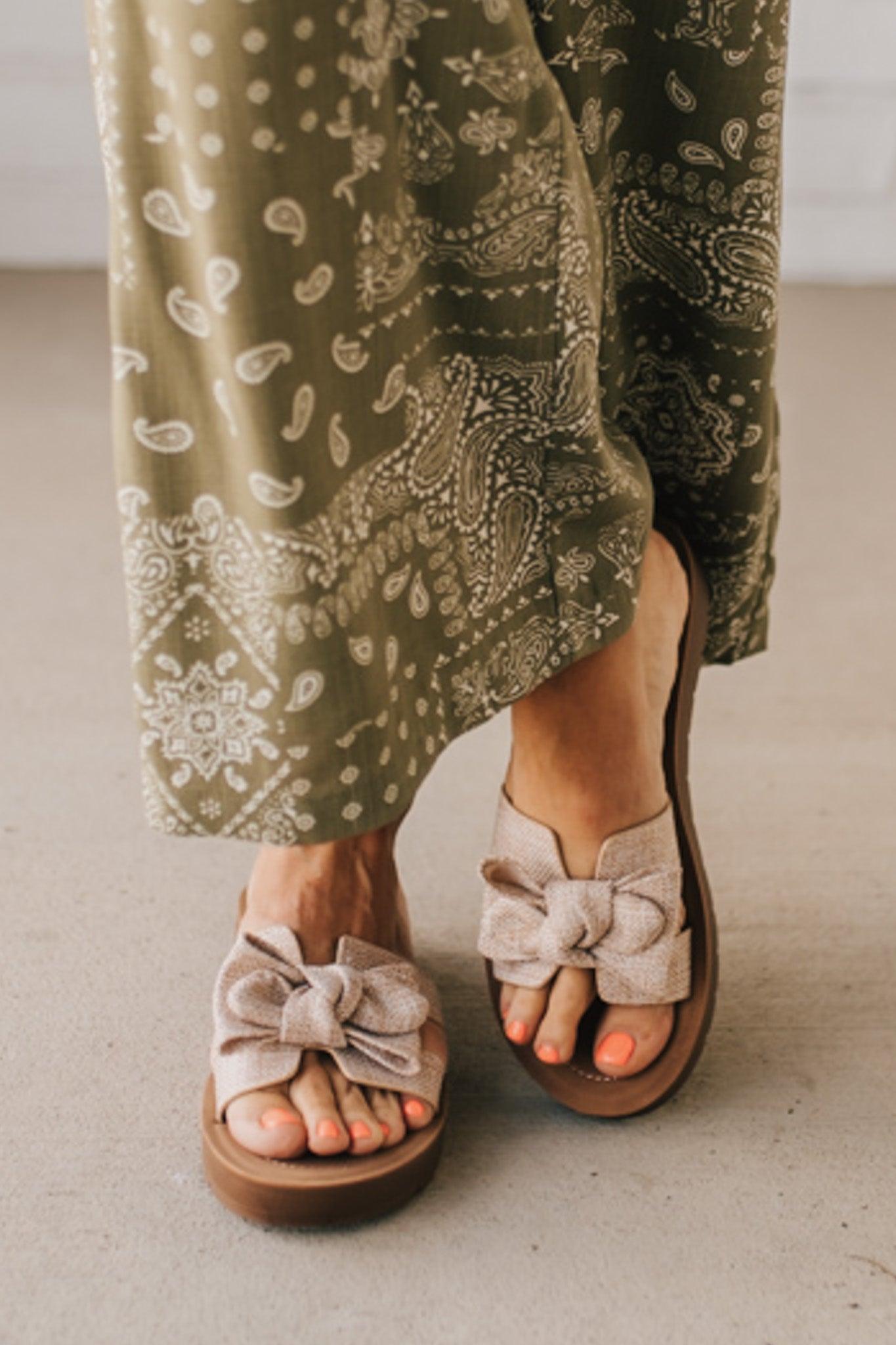 Woman wearing Bow Top Linen Slide Sandals with Taupe Linen Texture.