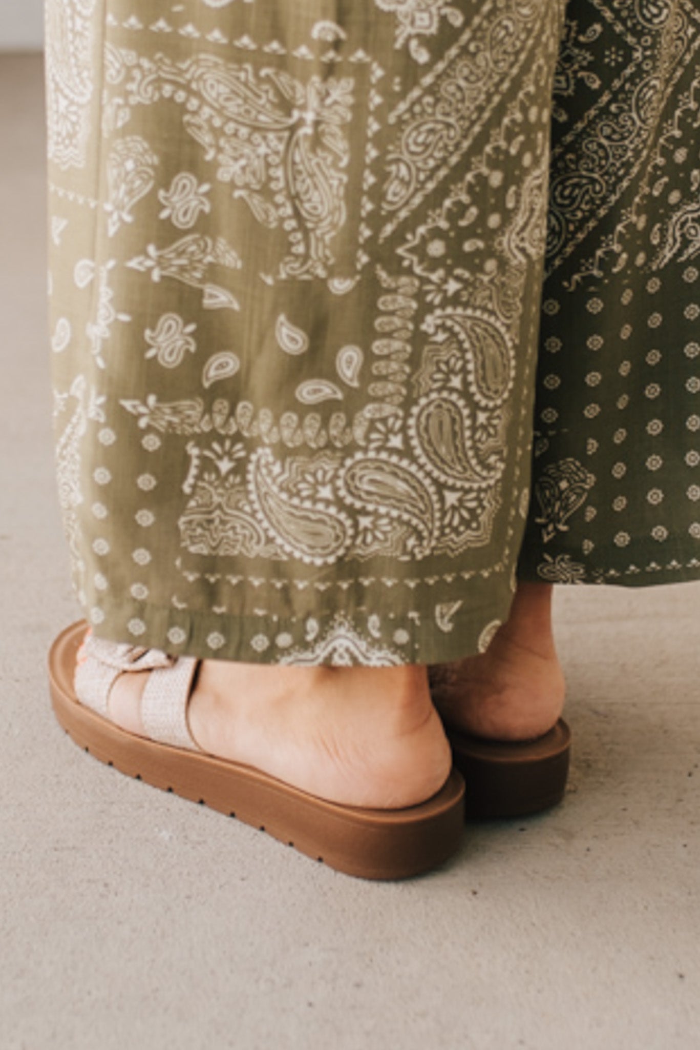 Woman wearing Bow Top Linen Slide Sandals with Taupe Linen Texture.
