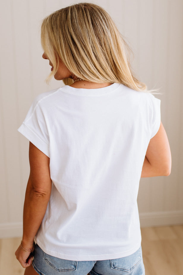 Person wearing a plain white t-shirt and light blue jeans against a neutral background
