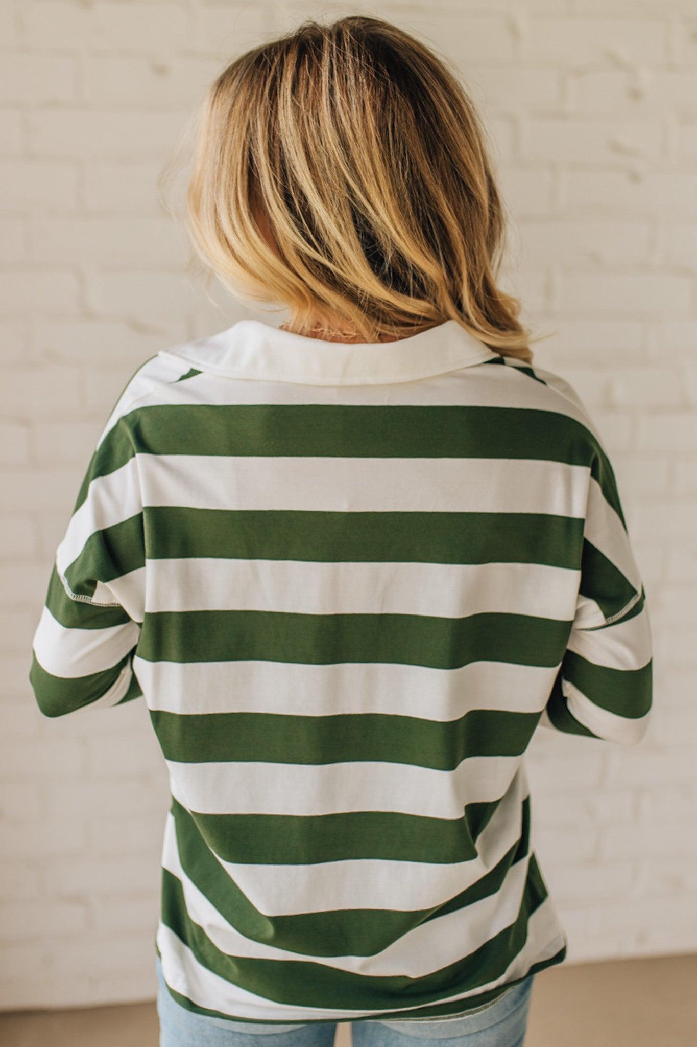 Person wearing a green and white striped shirt against a light background